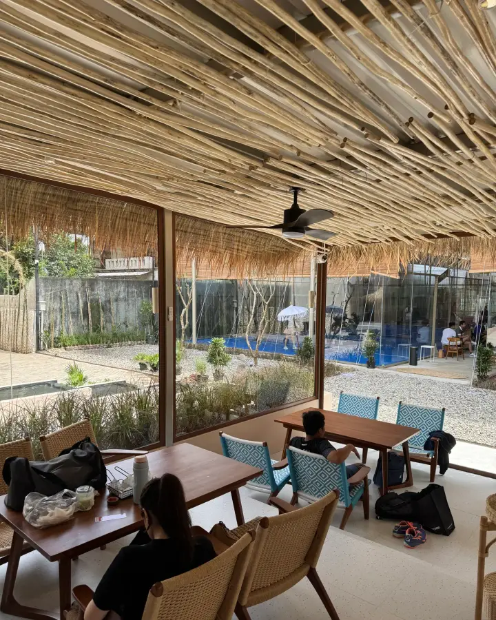 Tables under a bamboo ceiling beside the courts
