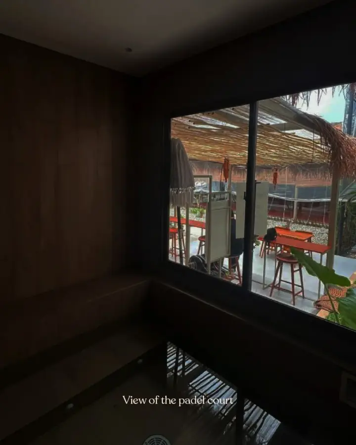 Dark timber cold plunge room with a window to the courts